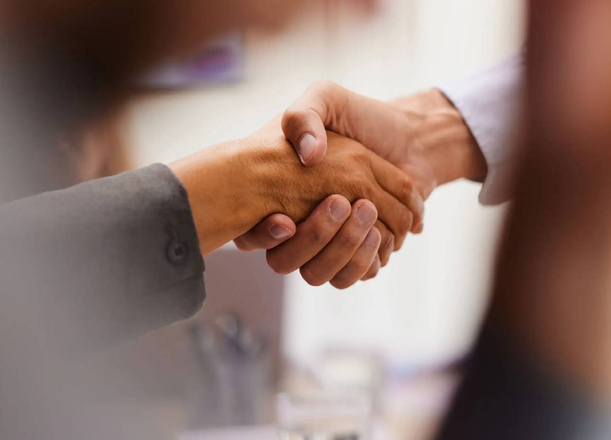 Two people shaking hands in a close-up shot.