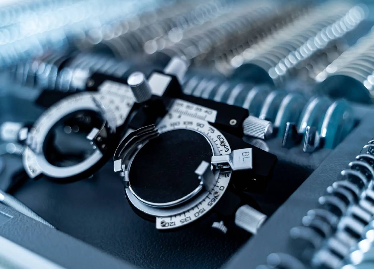 Close-up of handcuffs and metal springs on a dark surface.